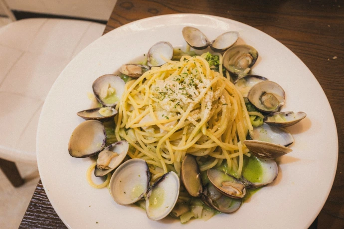 Spaghetti with clams and herbs on a white plate